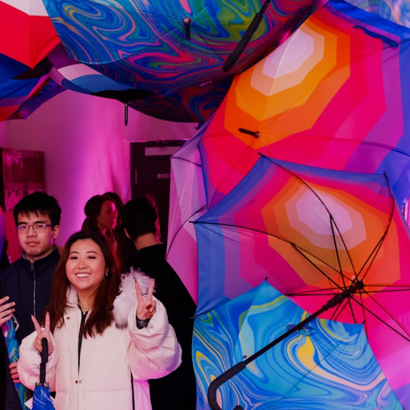 Two fans at a Lyft activation McGarrah Jessee created in Vancouver. The two people are surrounded by beautiful, colorfol, designed umbrellas, which was part of the activation.