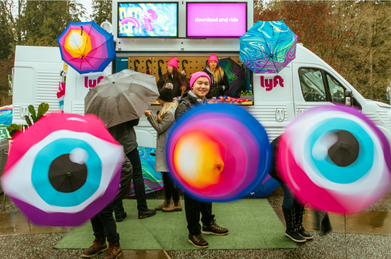 A photo of the Lyft Vancouver activation people posing and spinning the custom umbrella designs