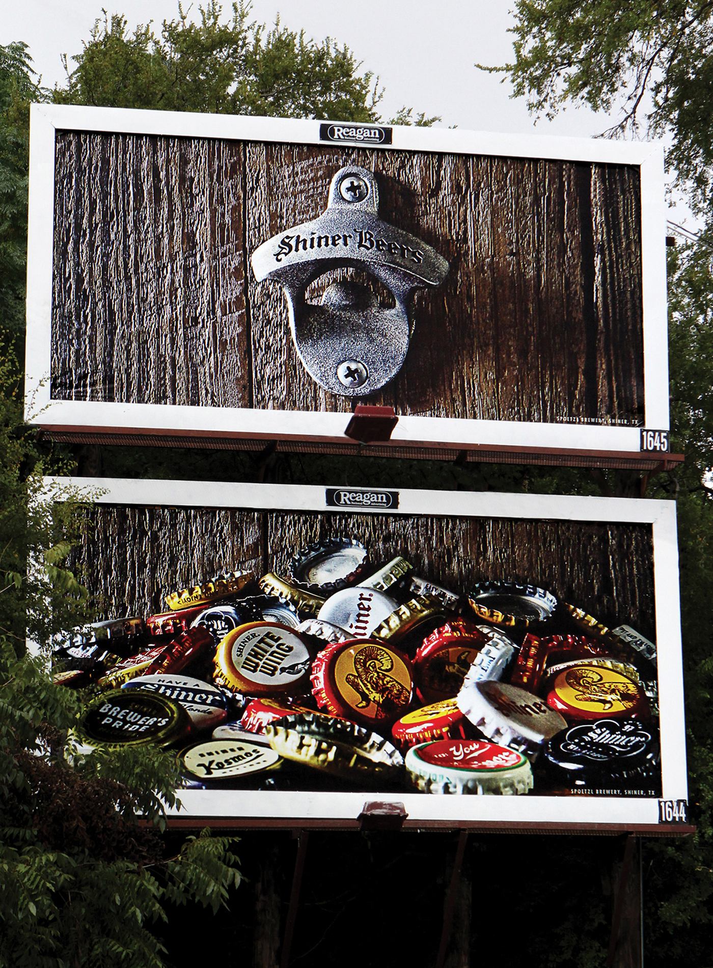 A photo of two billboards on top of each other. The first billboard features a close up of a bottle cap opener mounted to a wall that reads "Shiner beers." The second billboard is a pile of shiner bottle caps