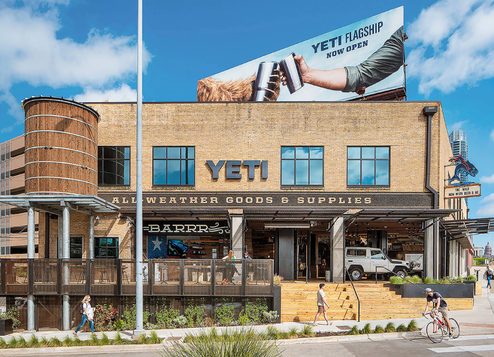 Architectural photograph of the YETI Flagship store with pedestrians walking by and patrons on the patio.